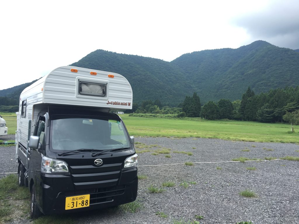 飛ぶ山の麓のキャンピングカー